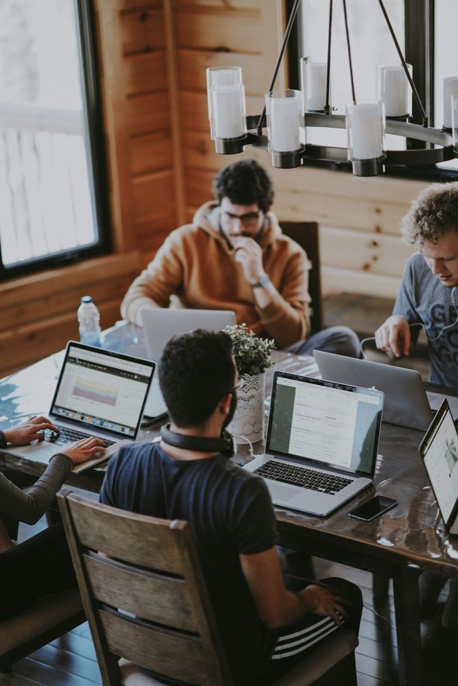 Office workers at desks in a corporate workplace representing AI's impact on tech jobs
